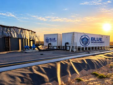 Two Blue Development water containers at sunset.