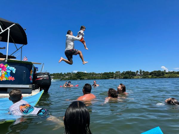 dad and son jumping off boat, ohana cruise, playing in ocean