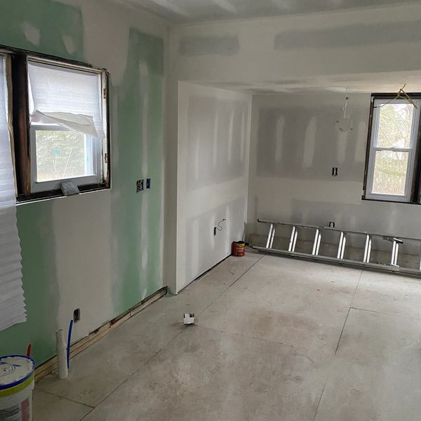 Room under construction with drywall and ladder.