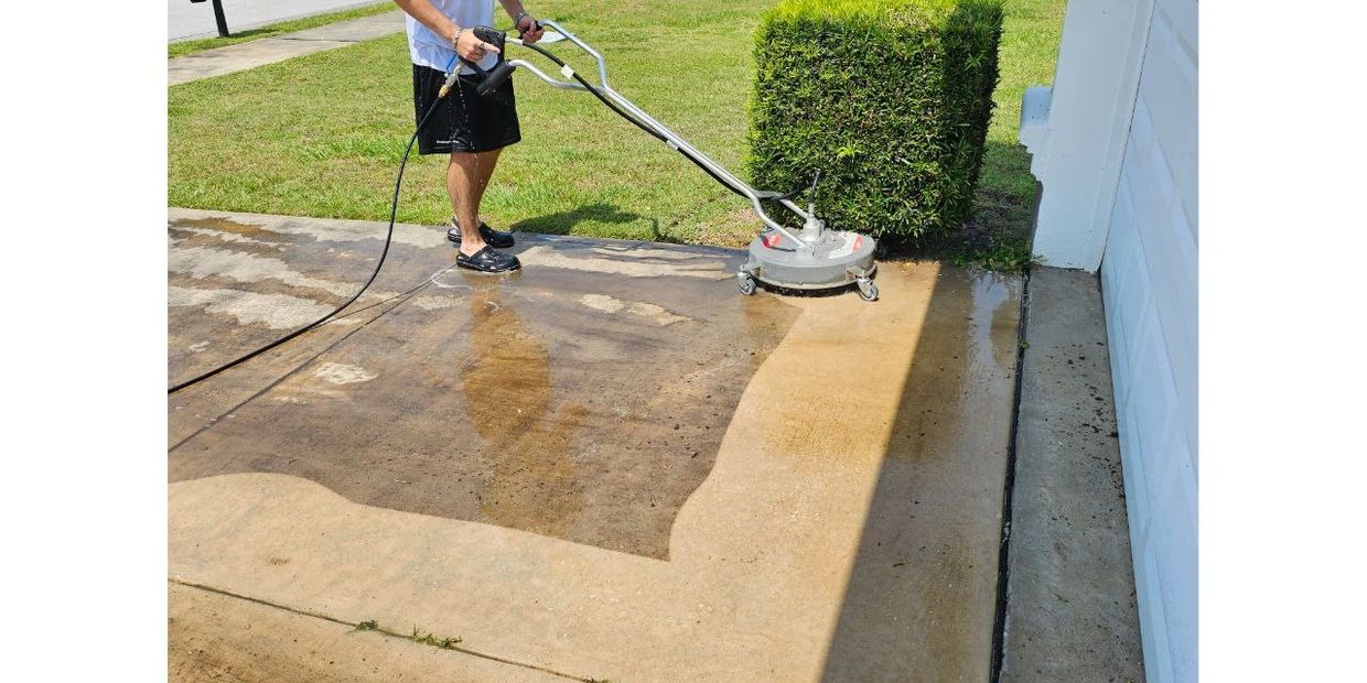 Man pressure washing a driveway to clean dirt and grime.