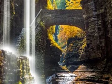 Two waterfall streams with a bridge in the background