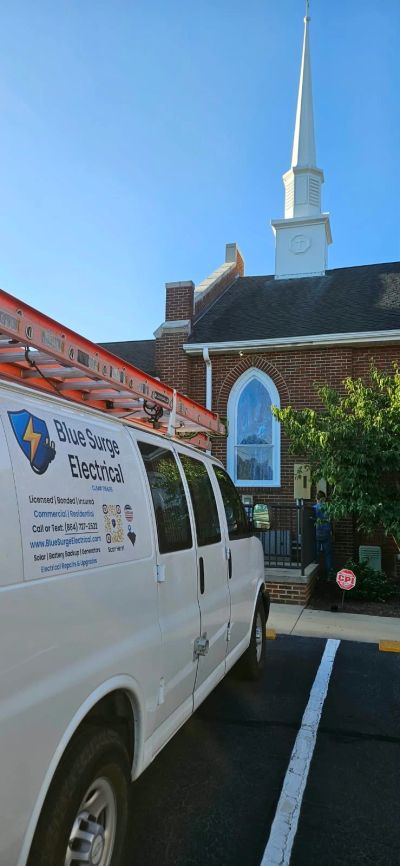Blue Surge Work Van In Front Of Steeple
