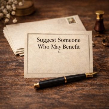 A vintage card reads 'Suggest Someone Who May Benefit' with a pen on a wooden table.