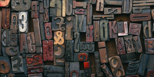 Assorted vintage printing blocks with various letters and numbers.