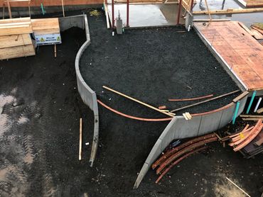 Exterior patio for a retirement home with curved retaining walls and stairs slopping down to the green space.