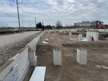 Construction site with concrete foundations and machinery.