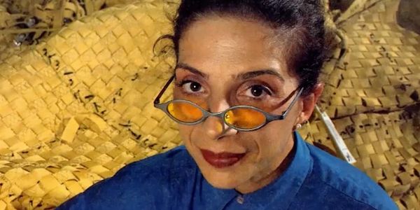 Woman wearing orange-tinted glasses and a blue shirt.