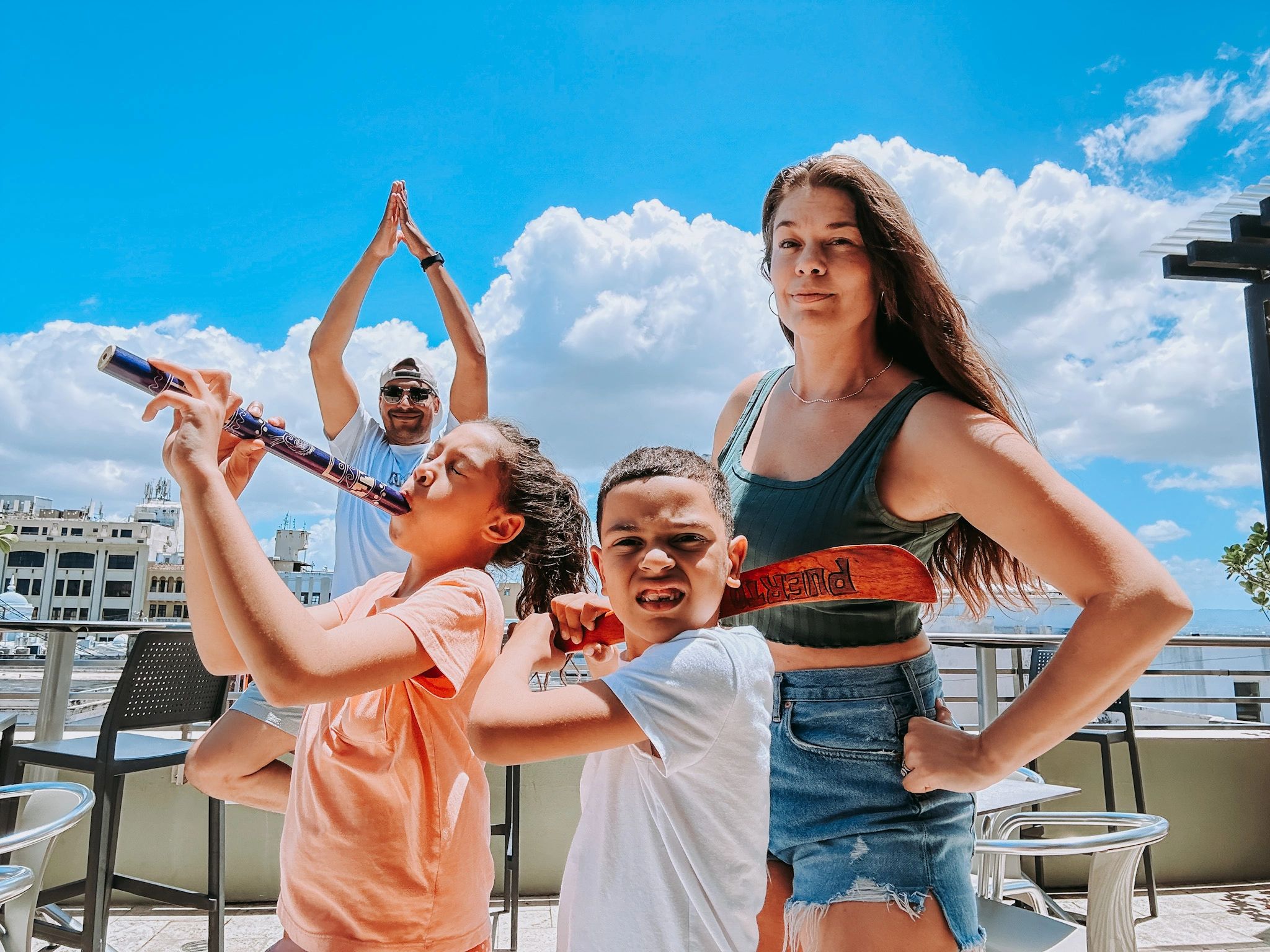 Group of people enjoying music and posing outdoors on a sunny day.