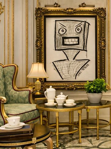 Elegant room with vintage furniture and abstract framed artwork.