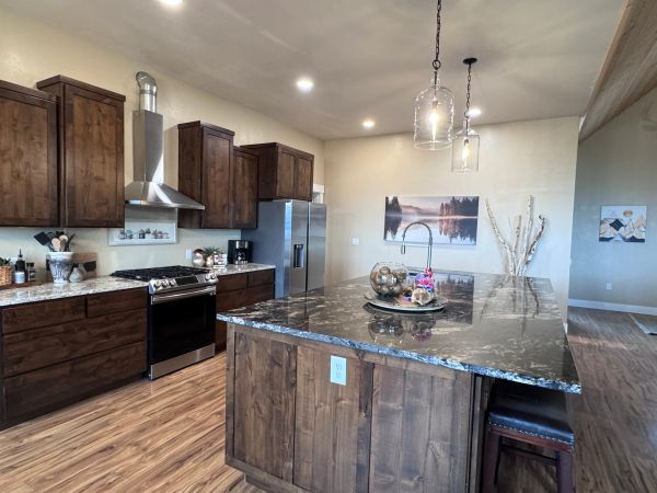 Modern kitchen with dark wood cabinets and a large marble island.