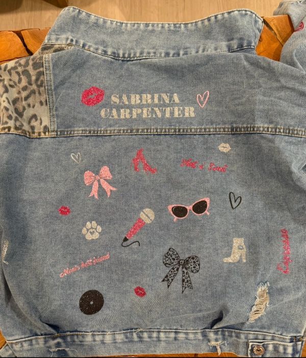 Denim jacket with Sabrina Carpenter design and colorful icons.