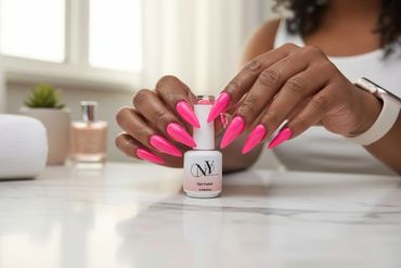 Hands with long, bright pink gel nails holding a nail polish bottle.