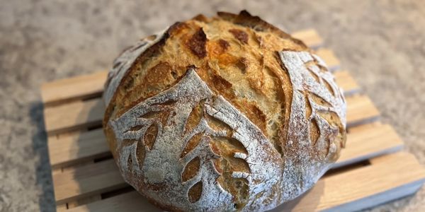 Freshly baked artisan bread with decorative leaf patterns.