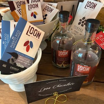 Artisan Loon Chocolate bars and bottled Elixir displayed on a wooden table.