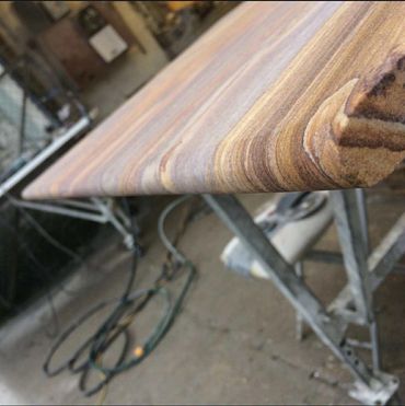 Close-up of a wooden board's edge with visible grain patterns.