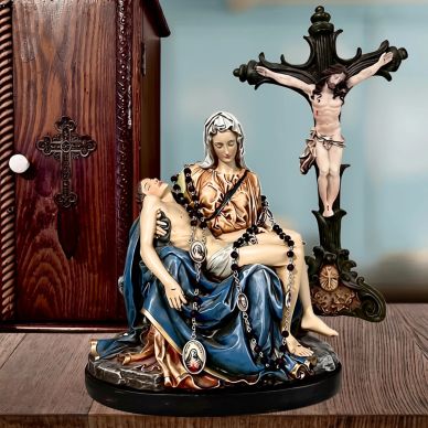 Religious statues including Pietà and crucifix on wooden surface.
