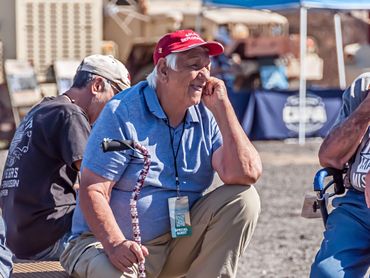 Military veteran watching the event with a red hat.