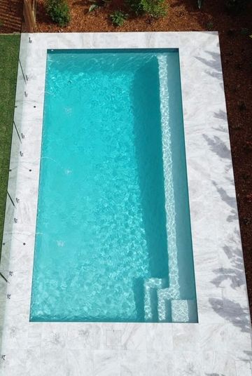 Rectangular swimming pool with clear blue water.