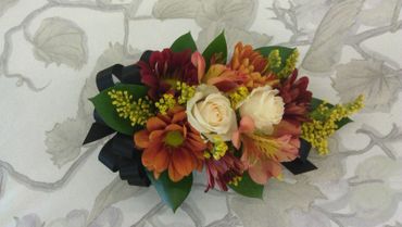 A corsage with orange and white flowers
