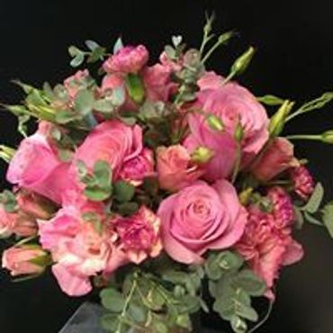 A pink and green floral arrangement bouquet