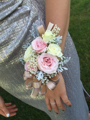 A light pink and white corsage with a copper ribbon