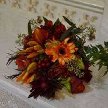A red and orange bouquet on white table
