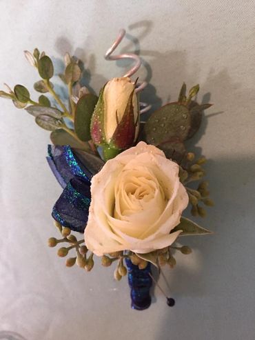A white rose and blue ribbon boutonniere