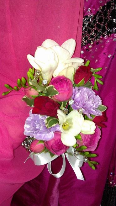 A corsage with pink white purple and red flowers