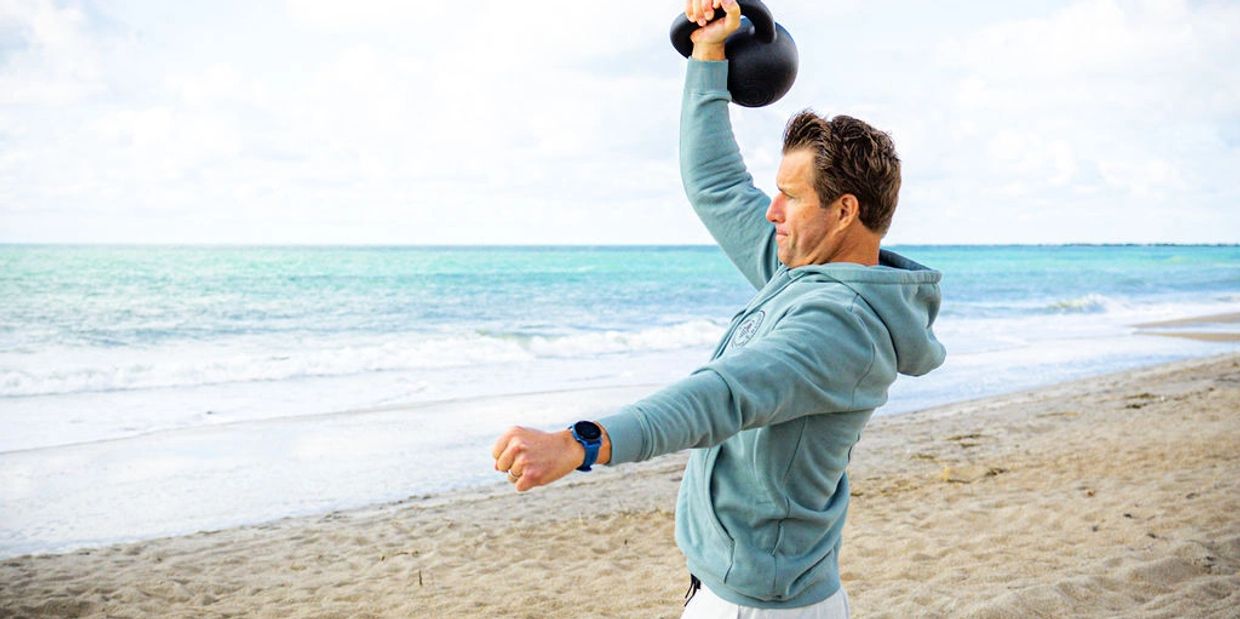 Josh Neubauer, StrongFirst kettlebell instructor, pressing kettlebell overhead at Wrightsville Beach