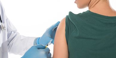 Cropped view of doctor doing vaccine injection to female patient isolated on white.