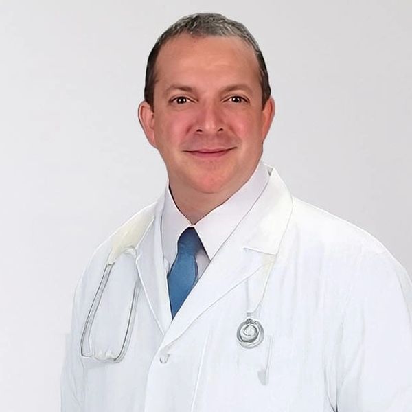 A close up of Dr. Michael Williams-Healy smiling and wearing a white lab coat.