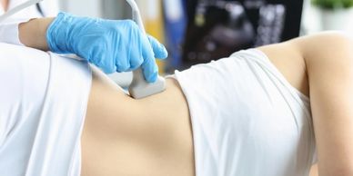 Woman undergoes ultrasound scan of kidneys and internal organs in clinic.