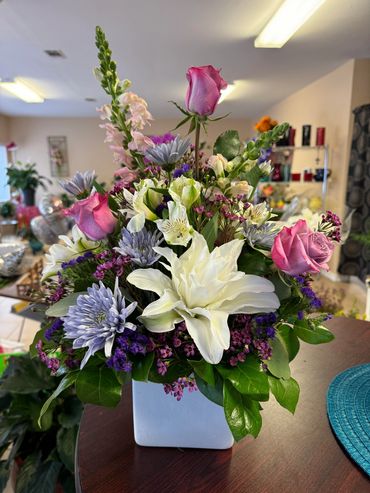 Lavender Roses, Pink Snap Dragons, White Double Lilies and assorted Flowers and greens.