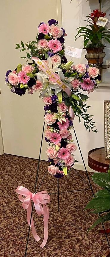 Cross with Pink Roses and Gerbras Lilies and Moon Carnations with Ribbon and Name or letters.,