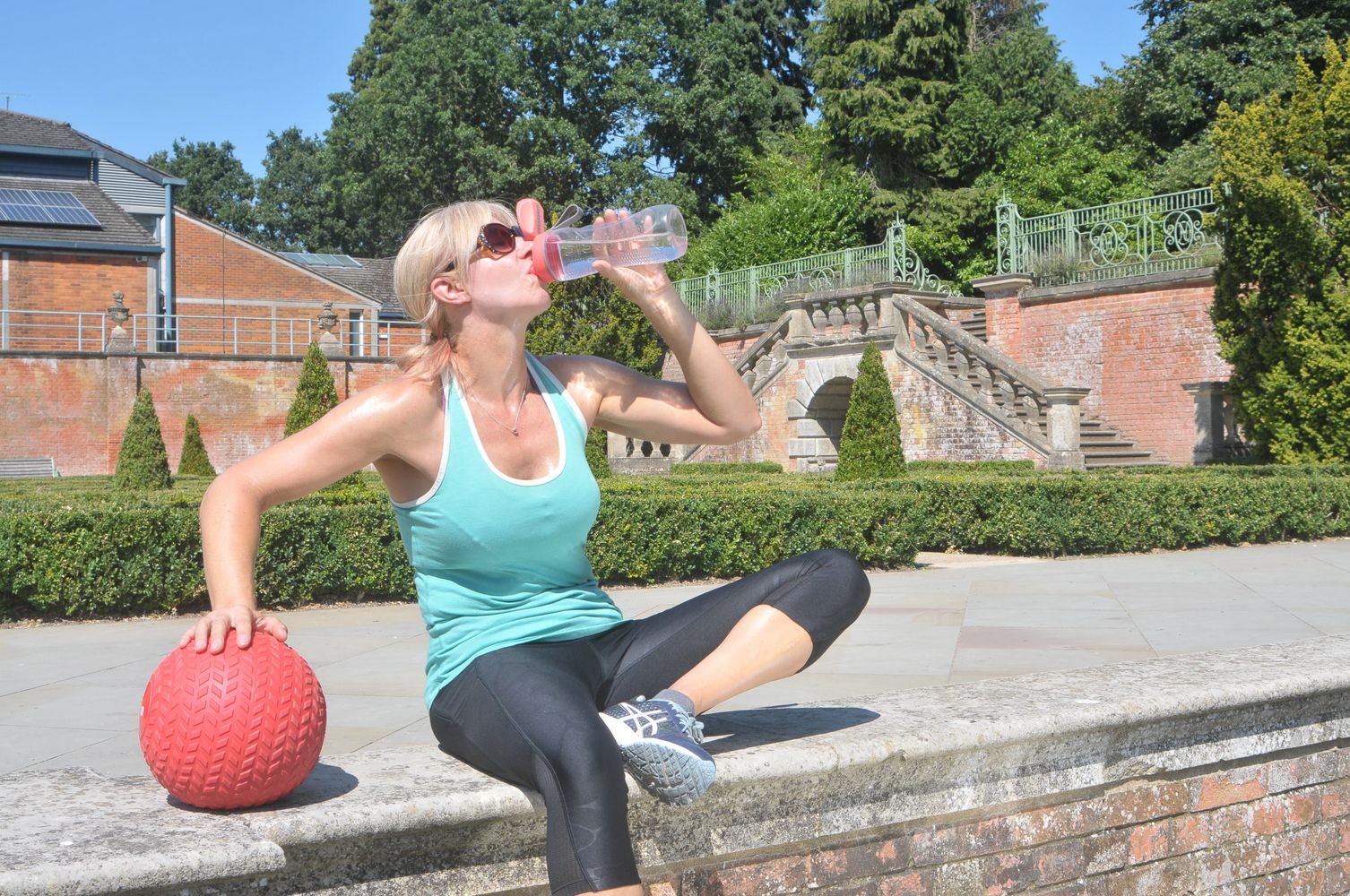 female fitness personal training woman in lycra drinking water outdoors hebden bridge