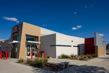 Exterior of Calibers Shooting Range with modern architecture and desert landscaping in Albuquerque.