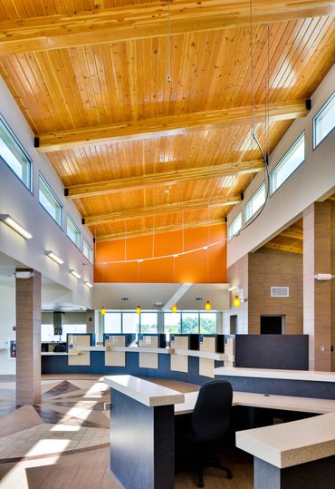 First Financial Credit Union interior with wood beam ceiling, natural light, and teller stations.