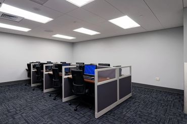 Modern workspace with individual computer stations and neutral finishes at DIA.