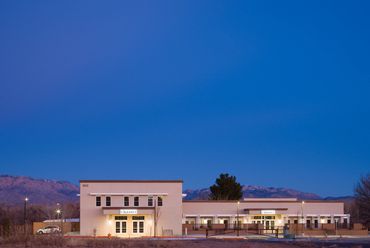 Legacy Home Health building illuminated at dusk with mountain backdrop and clean modern lines.