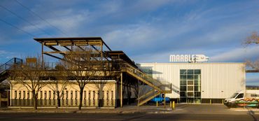 Exterior of Marble Brewing in Albuquerque with a metal stairway and modern industrial design.