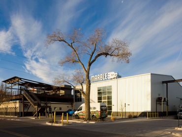 Marble Brewing exterior in Albuquerque featuring industrial architecture and rooftop deck structure.