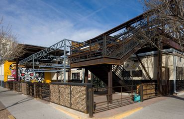 Exterior view of Marble Brewing with steel stairway leading to rooftop deck and patio seating area.