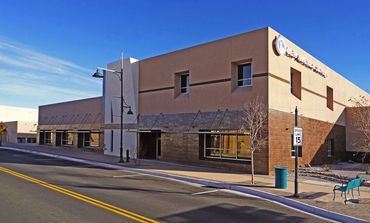 Two-story school building with modern stucco and brick façade, located along a city street.
