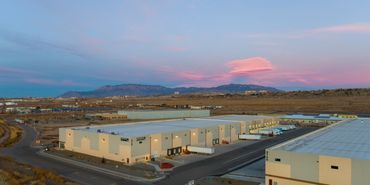 Aerial view of Prince Street Warehouse with truck bays and clean geometric façades at sunset.