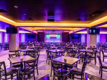 Quezada’s Comedy Club and Cantina main seating area with stage lighting and modern ceiling design.