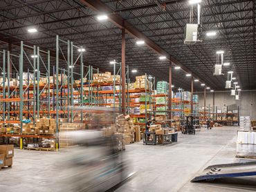 Expansive warehouse interior with organized racking and exposed structural steel ceiling.