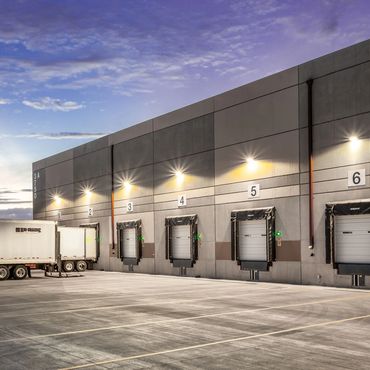 Truck loading bays at the Rio Grande Service Center with industrial lighting and a concrete facade.