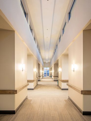 Bright corridor with clerestory windows and soft lighting inside a senior care facility.
