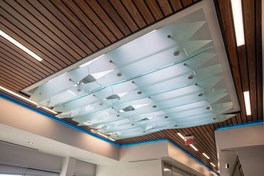 This custom ceiling features layered frosted glass panels with angular geometric cuts.