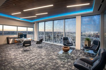 Executive office with modern seating, wood ceiling, and skyline view at SC3 International HQ.